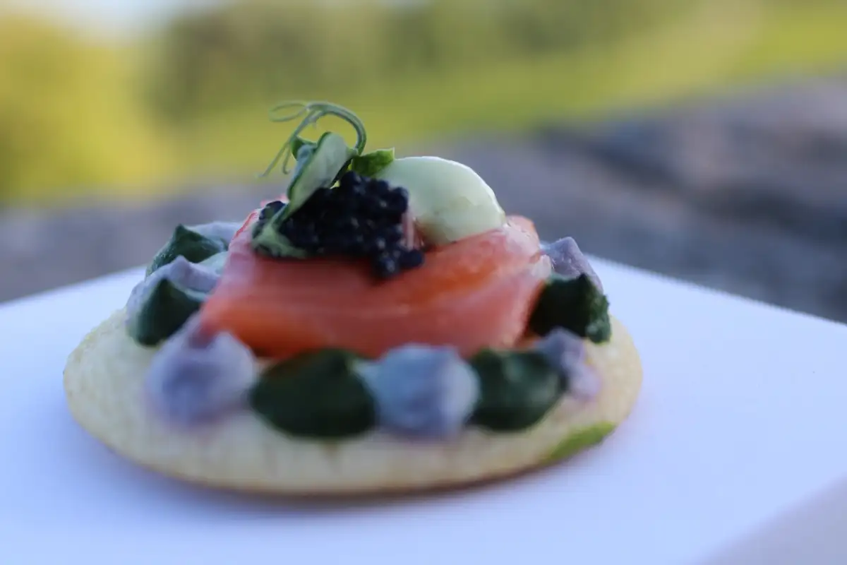 Blini au saumon fumé, caviar et pousses fraîches en gros plan