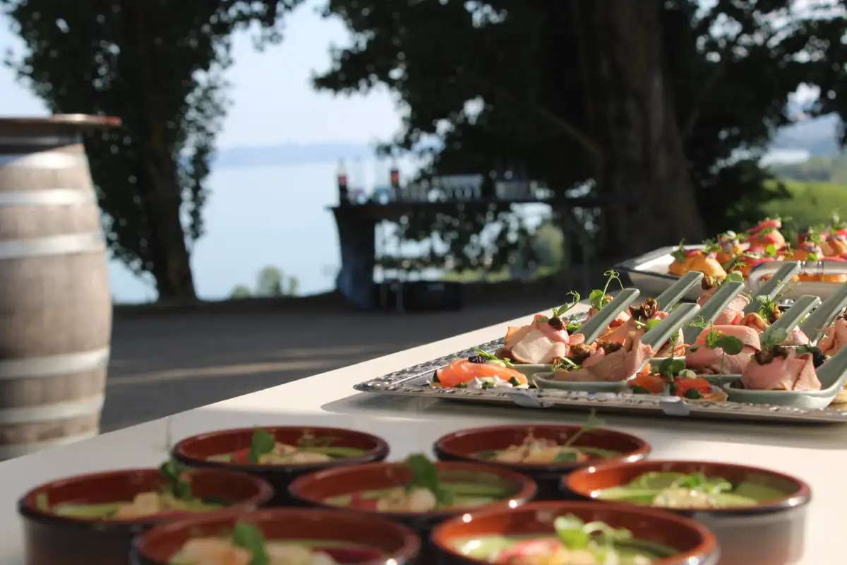 Table de buffet avec verrines et canapés, lac en arrière-plan