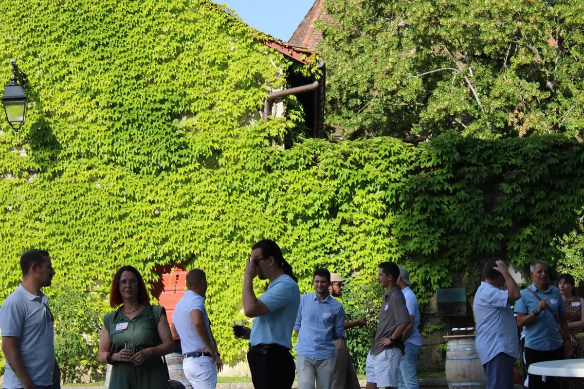 Invités partageant un moment devant la façade végétalisée