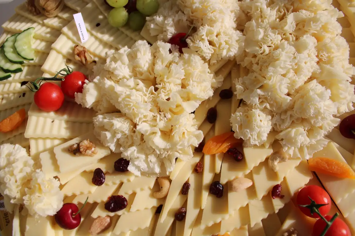 Plateau de fromages garni de tomates cerises, fruits et fruits secs